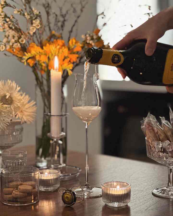 Warm brown-toned home bar space featuring champagne glass, candles, and vases creating cozy atmosphere on table