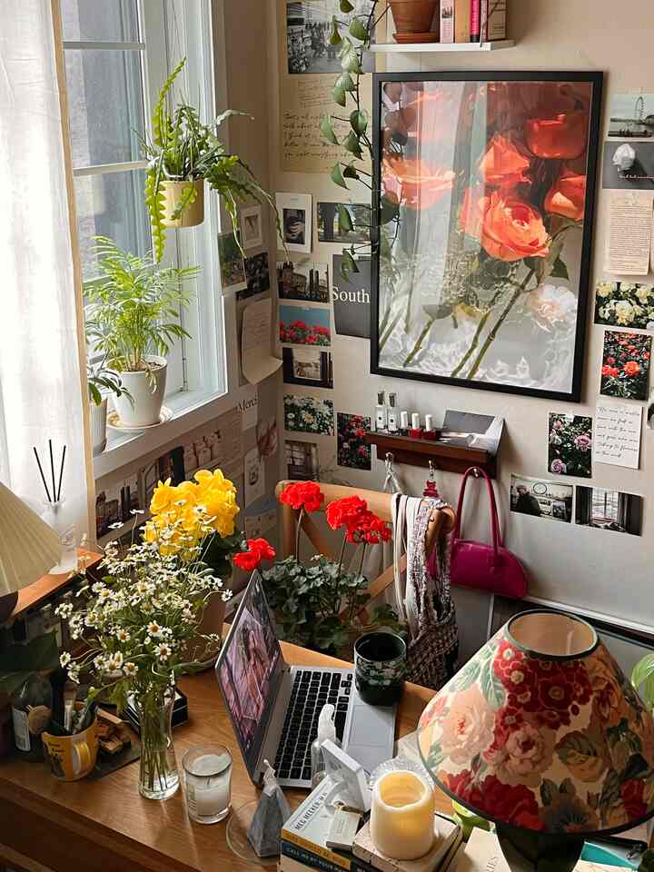 暖かいベージュ色調のワンルーム、植物とヴィンテージポスターが配置された雰囲気のあるホームオフィスと壁のインテリア