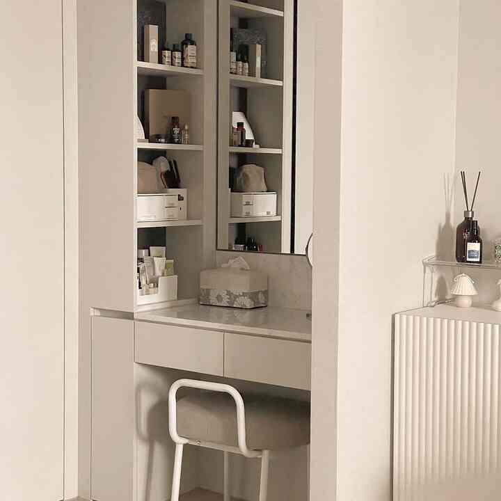 Beige-toned vanity with neatly organized storage cabinets in a minimal powder room space