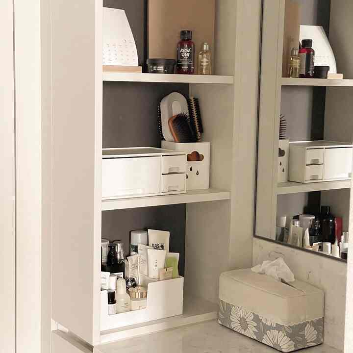 White and gray toned vanity storage area featuring clean storage boxes and shelves with a minimalist atmosphere