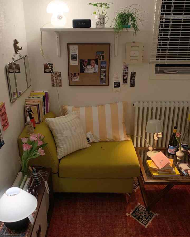 ホワイトの壁とイエローの一人掛けソファが配置された居心地の良い寝室、ヴィンテージラグとソファテーブルがポイントの自然な雰囲気のインテリア