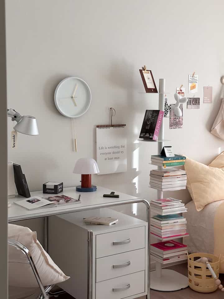 White tone bedroom featuring mid-century modern desk, shelves, lamps creating a cozy reading and workspace