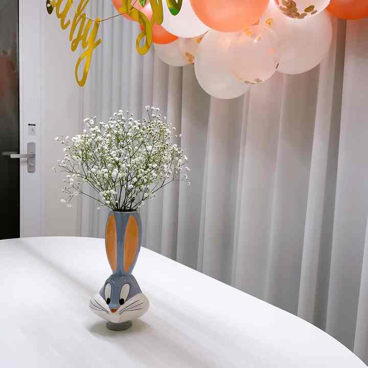 白を基調とした空間に中央にバニー形の花瓶と白い花が置かれたシンプルなインテリア