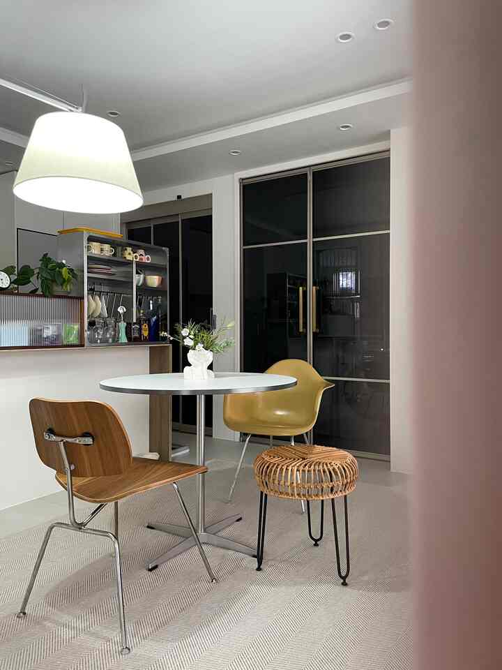 ホワイトと木目調が調和したモダンな二人暮らし向けリビング兼おうちカフェ空間、ラグと収納キャビネットが彩る雰囲気のあるインテリア