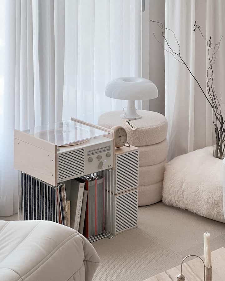 Bright natural-toned living room featuring a turntable, stool, and lighting with a minimalist and modern cozy atmosphere