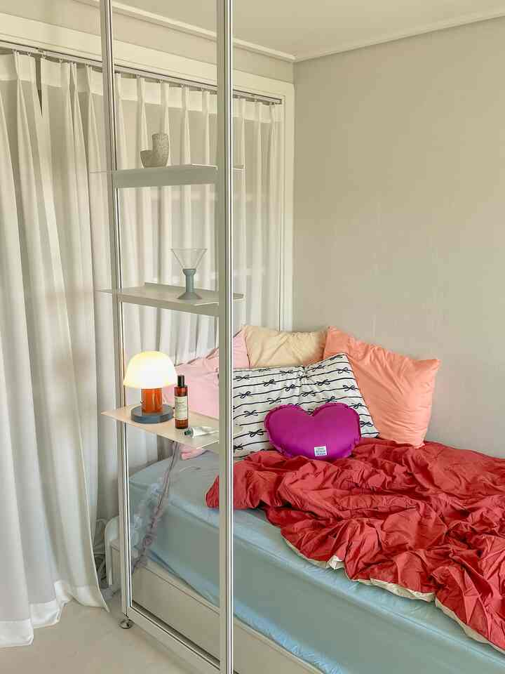 ナチュラルカラーの寝室、ベッドと枕、掛け布団カバーが配置された雰囲気のあるインテリア