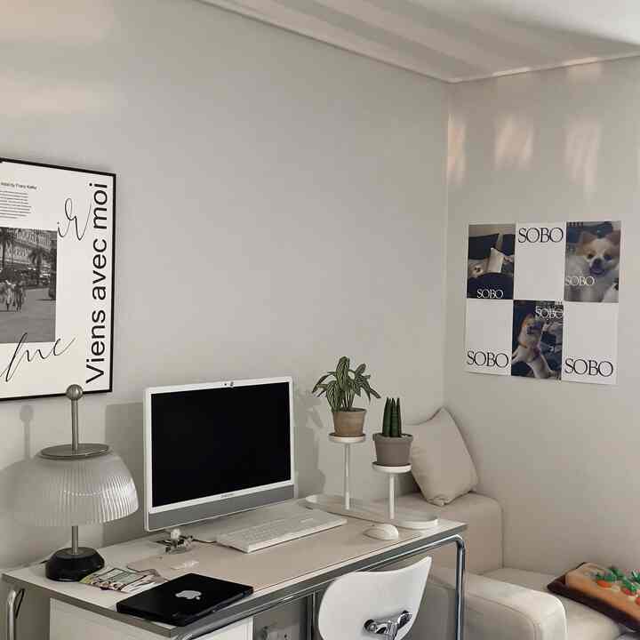 落ち着いたグレーのトーンのホームオフィス空間、白いデスクとコンピューター、プラントスタンドが配置されたミッドセンチュリーモダンスタイルのインテリア