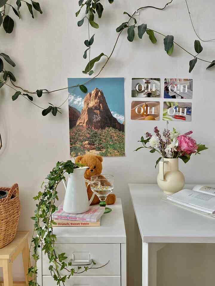 Natural and white-toned studio apartment home office featuring desks and vases with plants in a cozy setting
