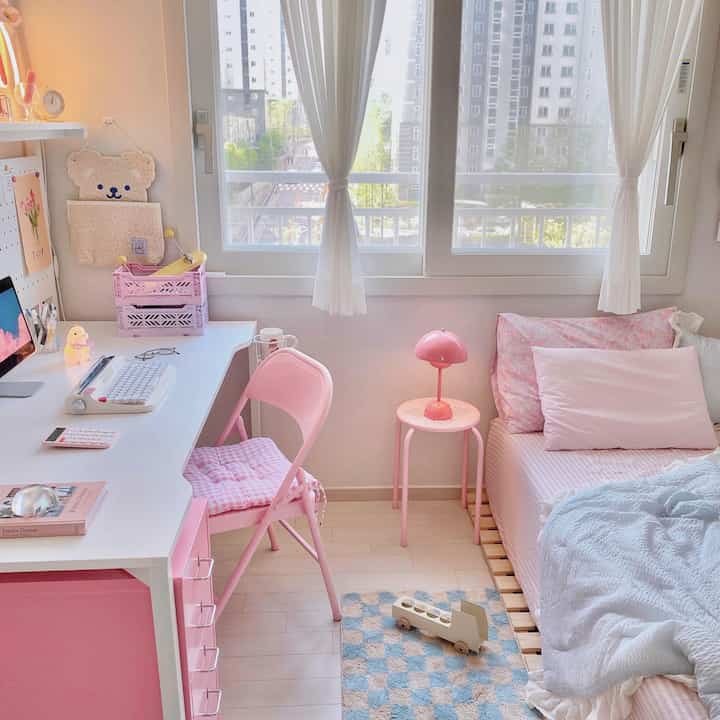 明るくかわいらしいピンク色調の子供部屋、デスクとベッドが配置された居心地の良い空間