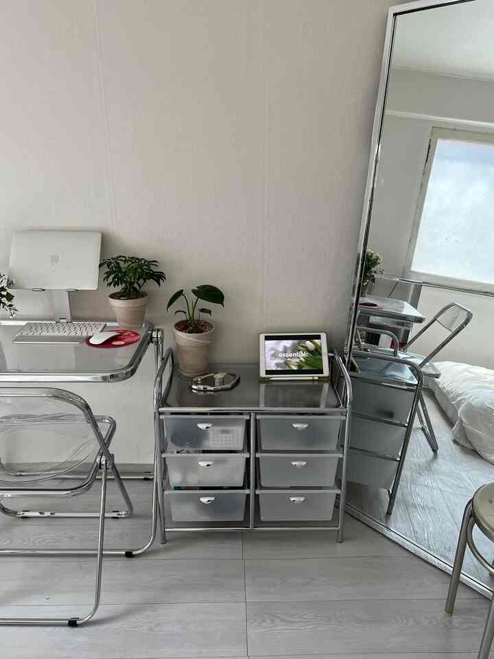 ホワイトとシルバーのトーンのコンパクトなホームオフィス、クローム家具と透明チェアが配置されたモダンな空間