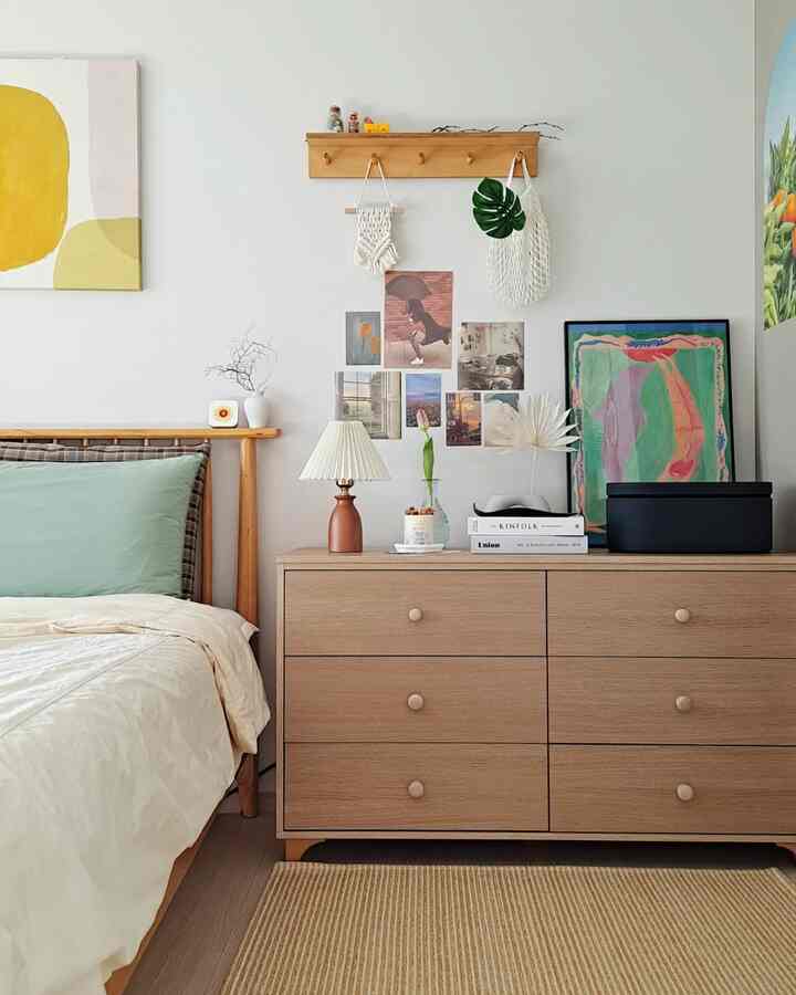 Natural wood tone and beige bedroom space featuring a wooden bed frame and large dresser in a clean minimalist style