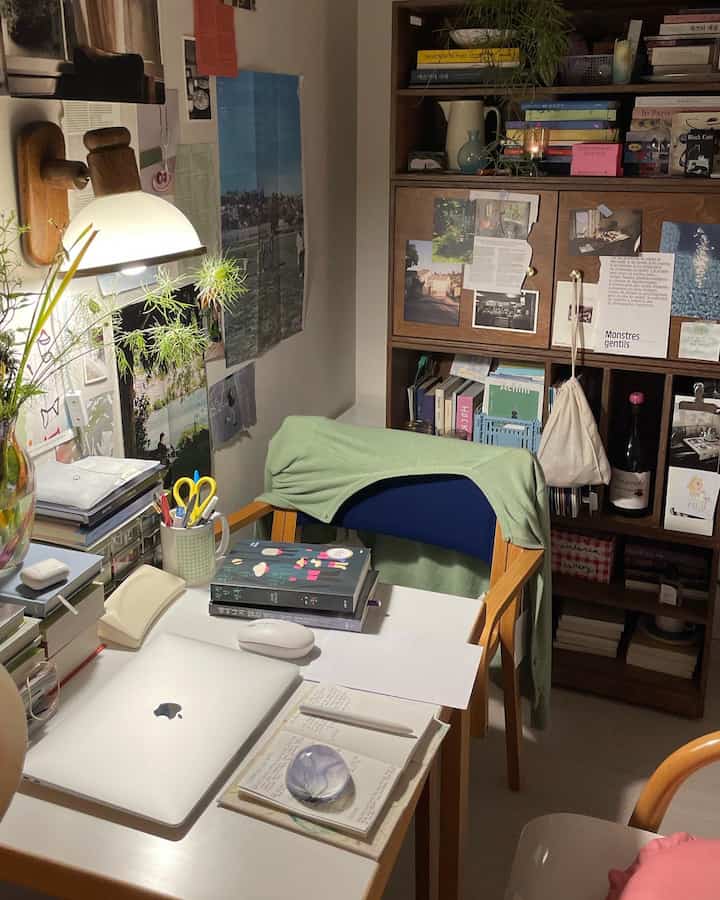 Natural color and white toned home office featuring wooden desk, cabinet, and wall sconce creating a cozy workspace