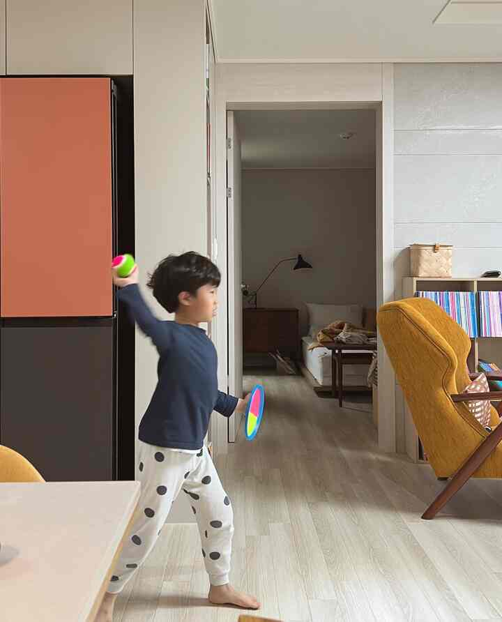 Beige-toned living room featuring yellow armchairs and a child playing, creating a family-friendly atmosphere