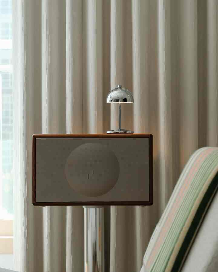 Soft beige-tone blackout curtains with wood-framed speaker in a calm interior setting