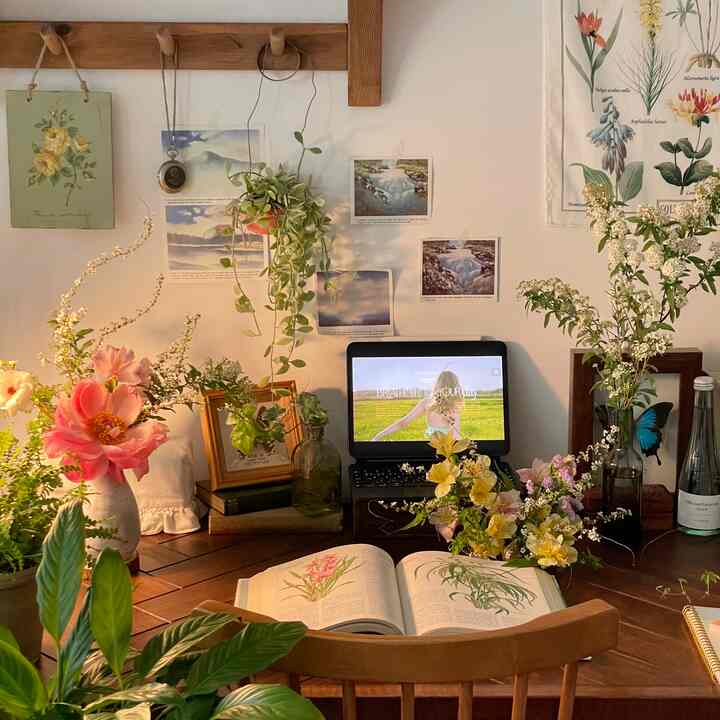 Warm beige wall and wood tone dining desk featuring various flowers and vases in a natural and cozy flower interior space
