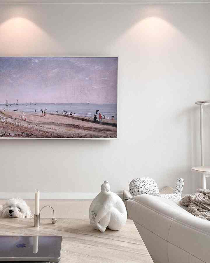 アイボリーとナチュラルトーンのリビングルーム、大きなソファとテーブルに花瓶とキャンドルが配置された雰囲気のある空間