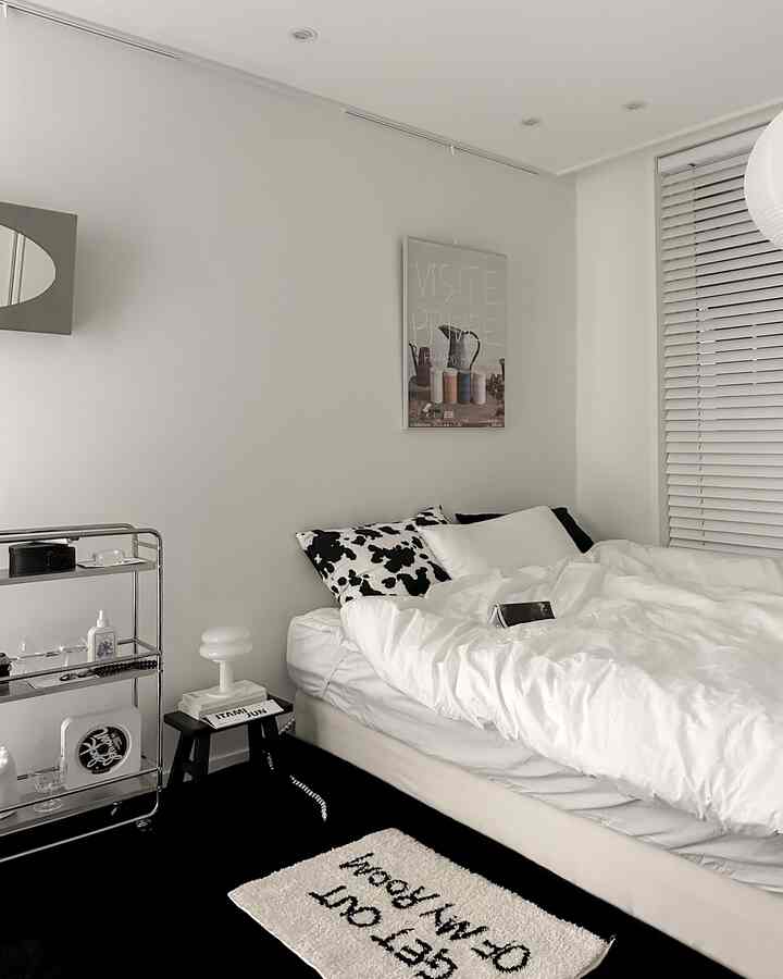 White and black toned bedroom featuring a large bed and modern furniture in a simple setting