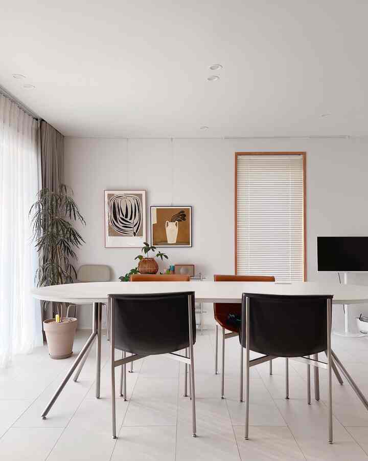 White and brown toned dining room featuring dining table, chairs, and plants with a clean modern atmosphere