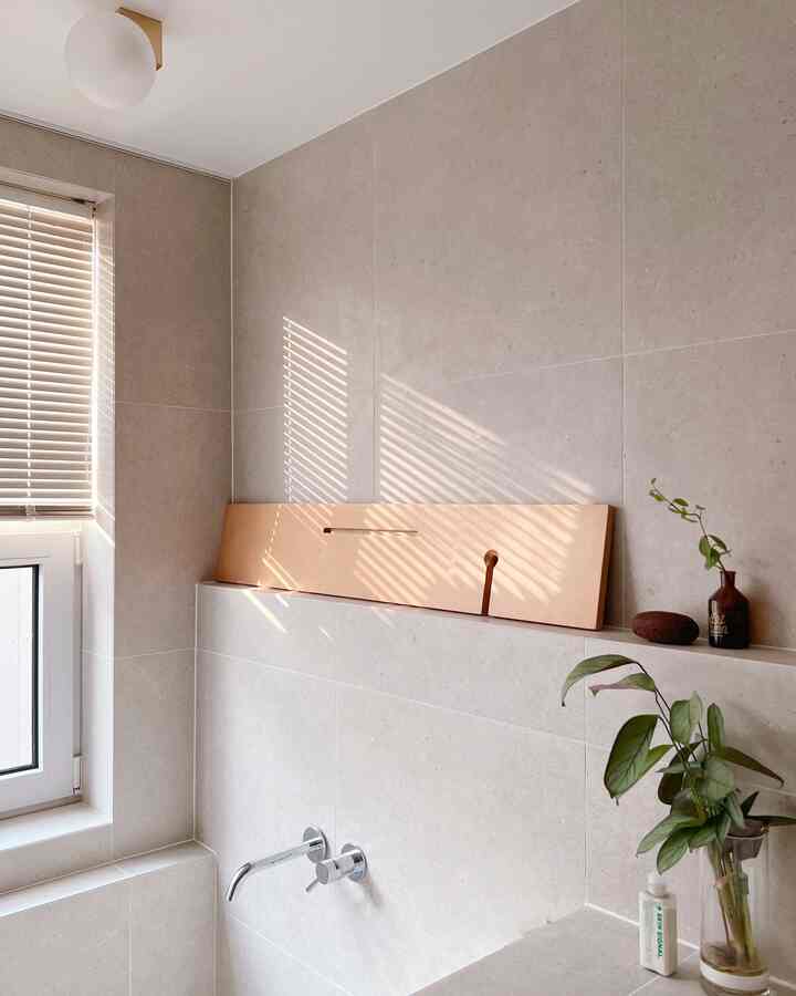 Bathroom space in beige and natural tones, featuring blinds and plants with a simple, cozy interior