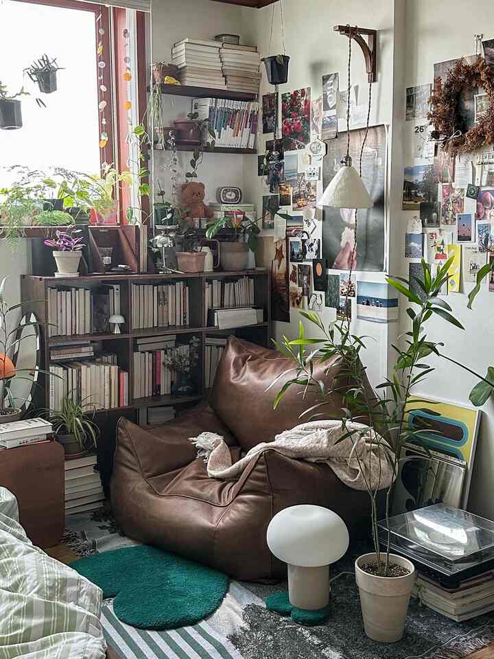 Natural-toned living room corner featuring a brown leather sofa and various plants creating a cozy atmosphere