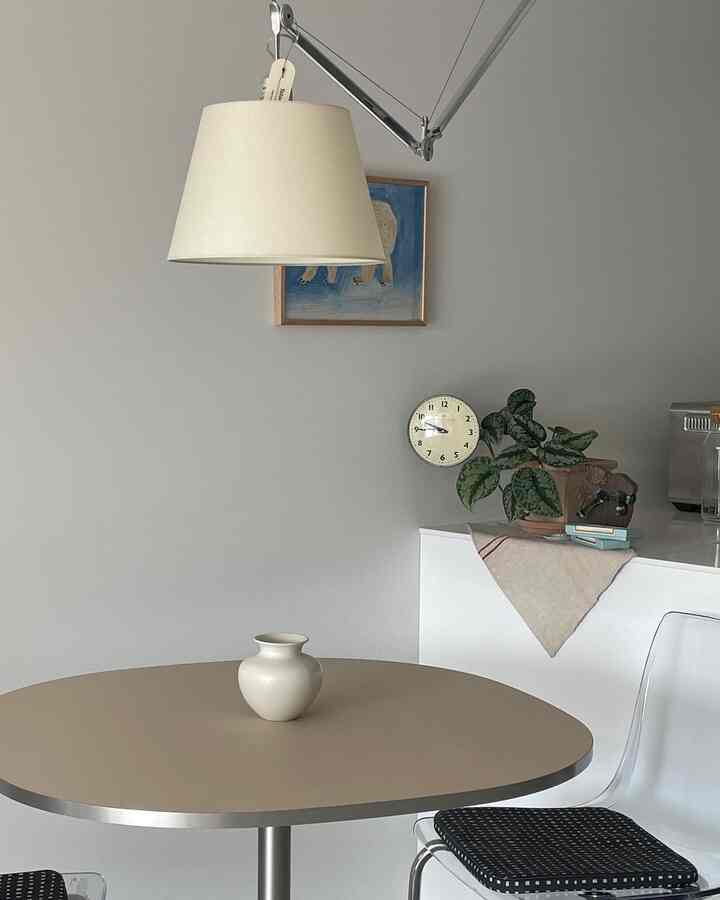 Beige-toned kitchen and dining area featuring a simple vase on the modern dining table