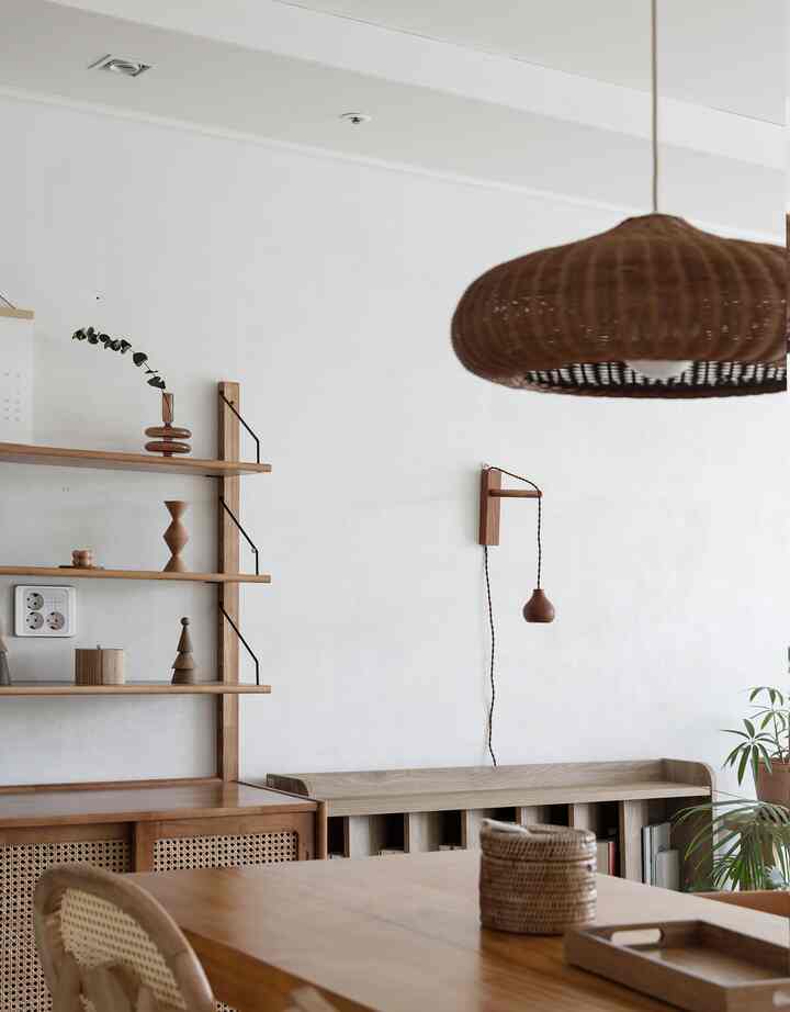 Natural wood-toned kitchen featuring rattan pendant light and dining chairs with a cozy atmosphere