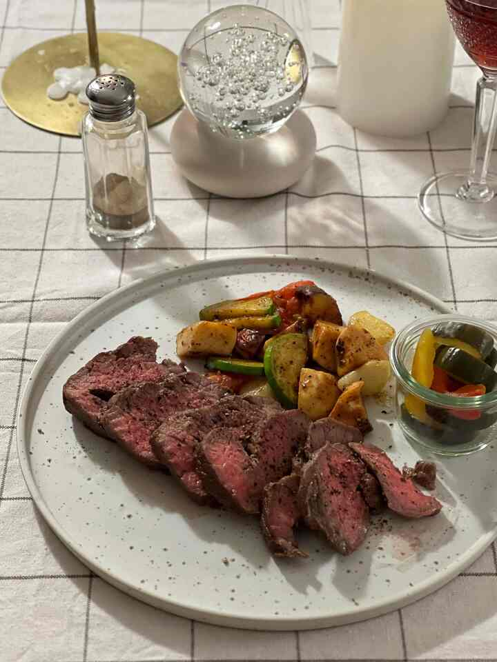 Retro home cafe dining space with steak plated on white checkered tablecloth