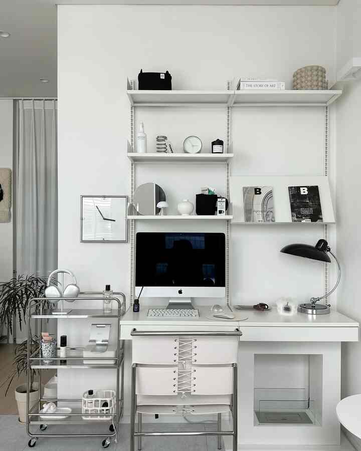 White and silver toned home office featuring a clean desk with modern furniture in a minimalistic atmosphere