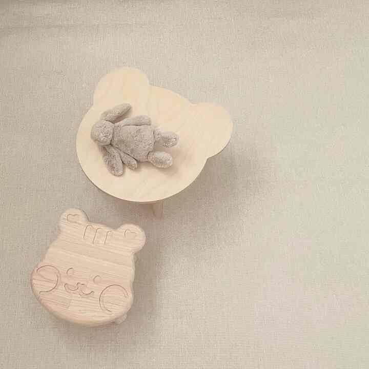 Beige-toned kids' room featuring cute wooden bear-shaped table and stool, designed as safe baby furniture