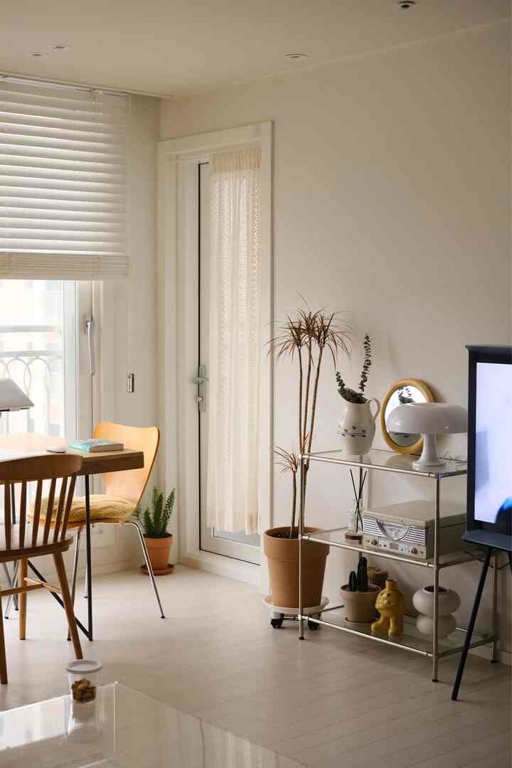 ホワイトとナチュラルトーンのリビングダイニングルーム、ウッドのダイニングチェアとレトロな装飾が調和した雰囲気のある空間