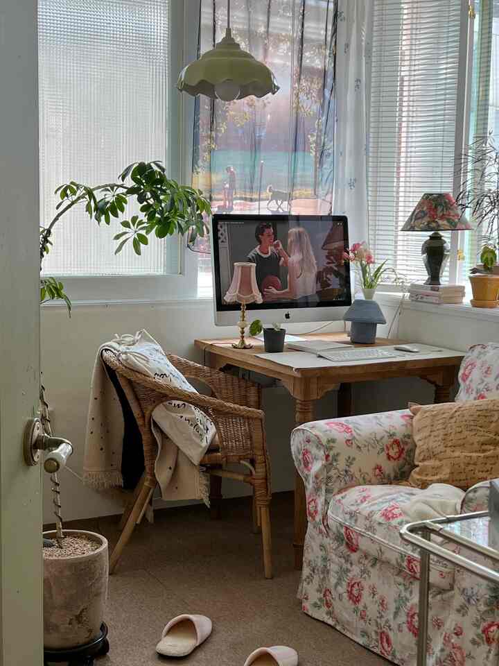 ナチュラルな色調の書斎兼ホームオフィス空間、木製の机とラタンチェア、フロアランプと植物が配置された落ち着いた雰囲気のインテリア