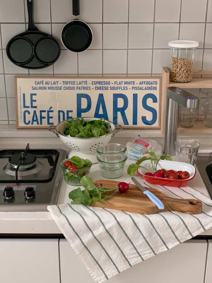 White tiled wall kitchen featuring cutting board and fresh vegetables creating healthy cooking vibe