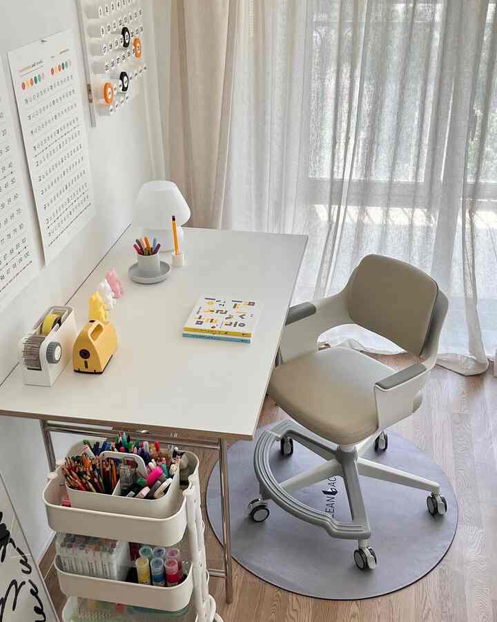 ベージュ色調の子供部屋、子供用デスクと調整可能なキャスター付きチェア、円形ラグが配置された落ち着いた学習空間