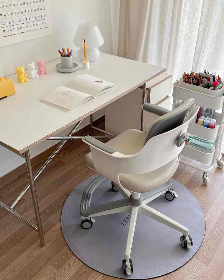 Natural-toned kids' study area featuring a white desk, adjustable children’s chair, and a storage cart, creating a cozy workspace
