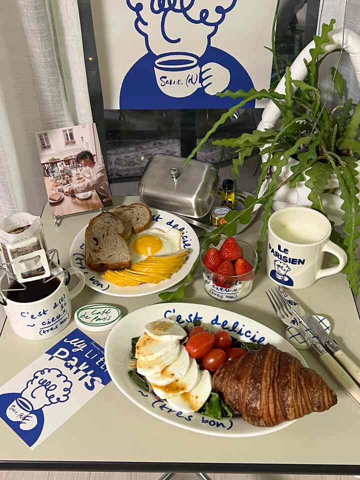 White and blue toned cafe-style dining table featuring croissant and brunch, creating a relaxed home cafe atmosphere