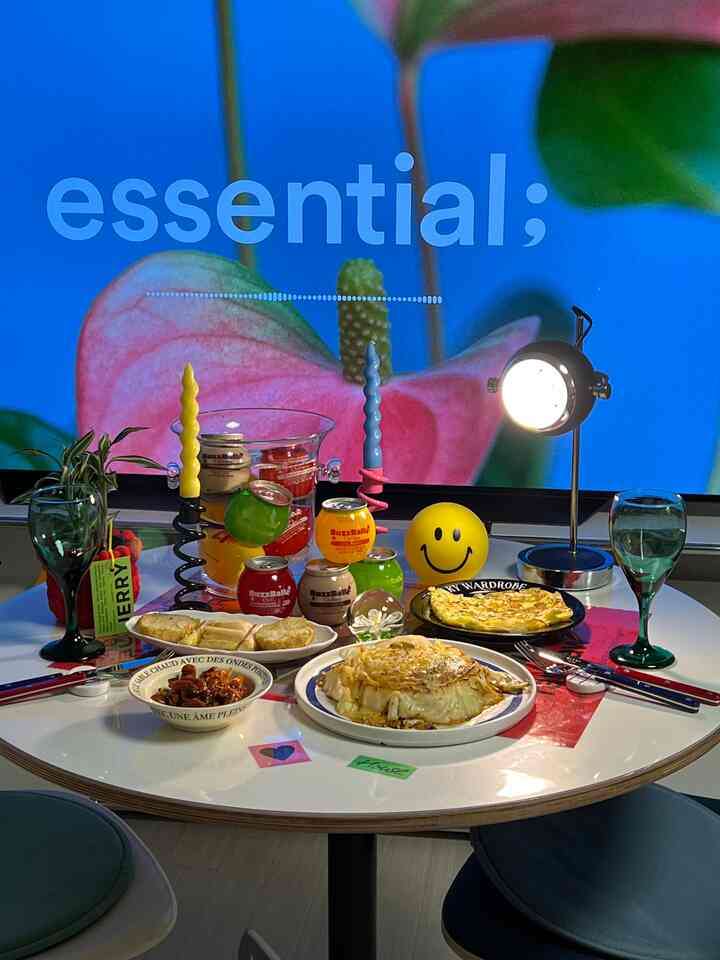 Blue backdrop with white round dining table in dining room, modern home party setup featuring candles and various dishes