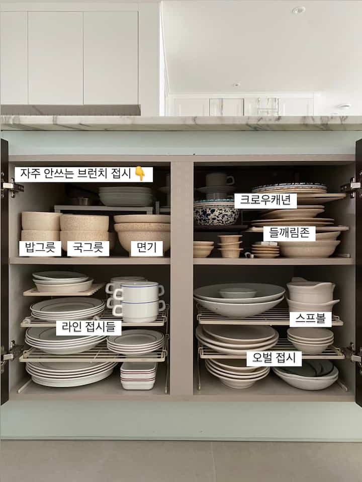 白と茶色のキッチンキャビネット、整然と並べられた皿とボウルが効率よく収納された雰囲気のあるインテリア