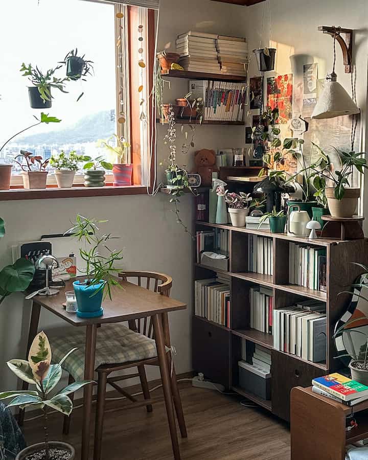 Cozy small room with warm wood tones and numerous plants, featuring natural light from window enhancing the plant interior style