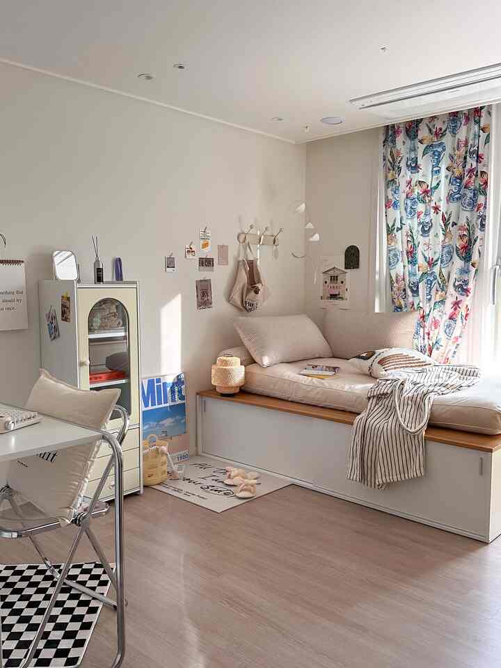 Natural toned bedroom featuring wood-accented bed frame, cushions, and checkered rug in a cozy setting