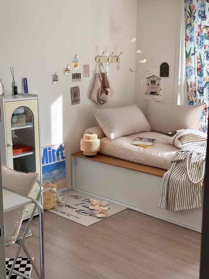 Cozy compact single household room in soft beige and natural wood tones featuring a sliding bed frame with cushions