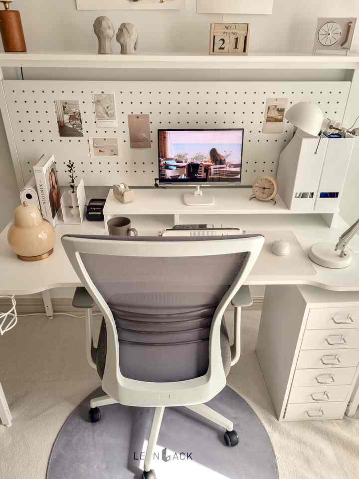 White and gray toned home office space featuring a breathable mesh office chair and organized desk setup with a clean, minimalist interior.