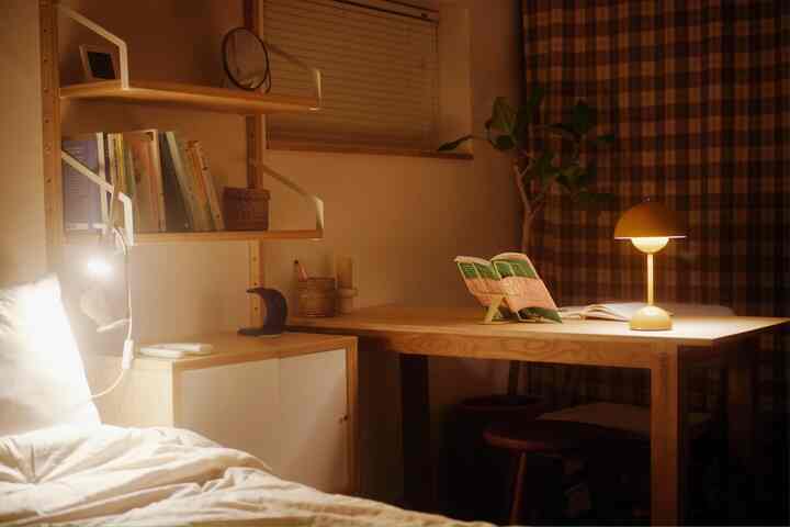 Brown and wood tone bedroom featuring a desk and warm table lamp, creating a cozy natural atmosphere