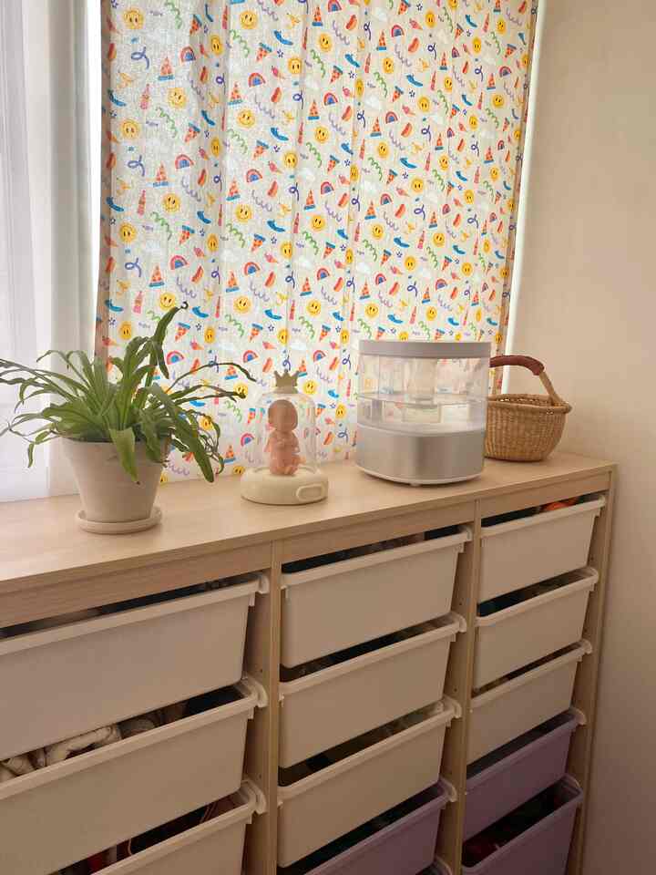 Natural tone kids' room featuring multi-drawer storage cabinet with baby doll and decor accents creating a cozy atmosphere
