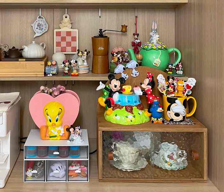 Warm wood tone home cafe area featuring various Disney character decorations, teapots, and a charming storage cabinet setup