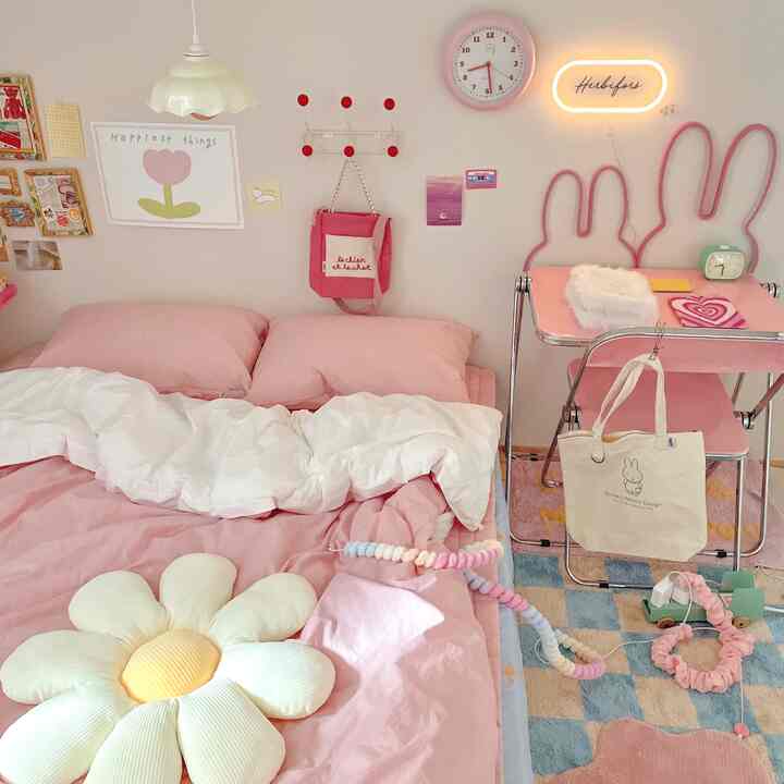 柔らかなピンク色調の寝室、デイジークッションと小さな机が配置された雰囲気のある赤ちゃん部屋