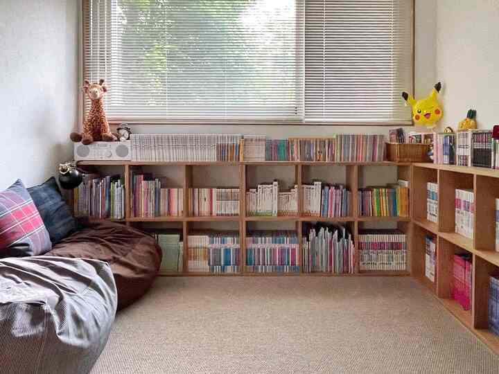 Natural-toned kids' room featuring wooden bookshelves and soft sofas, creating a cozy atmosphere