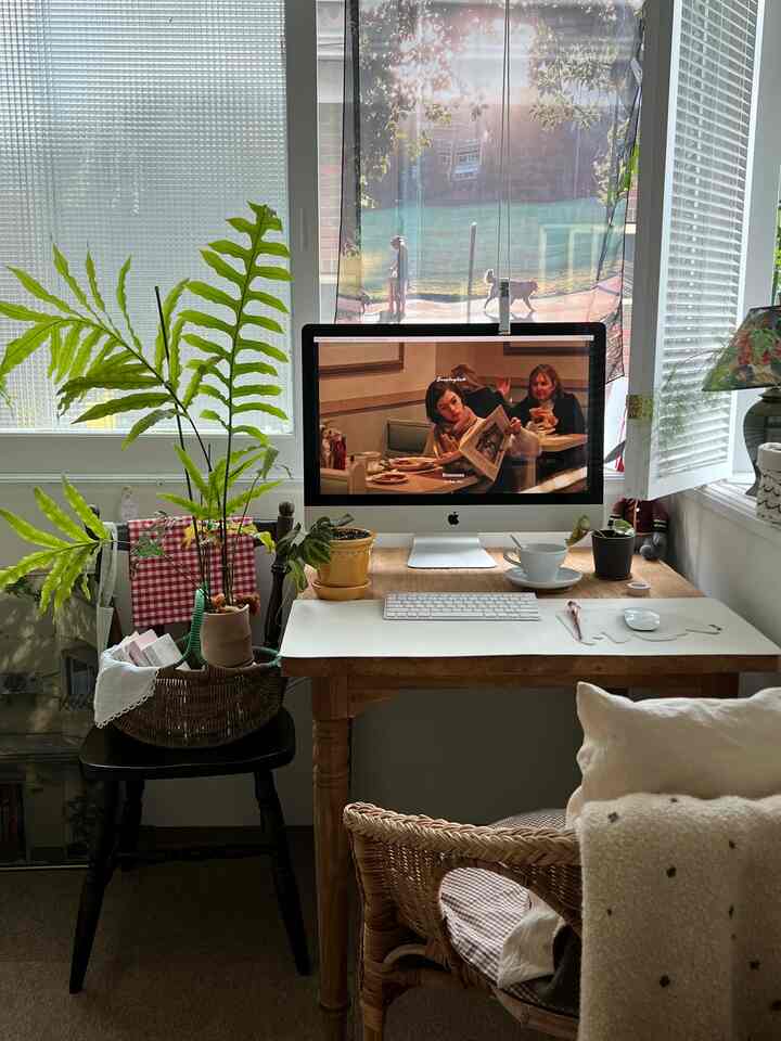 Brown wood tones and beige natural home office space featuring a rattan chair and green plant with cozy cafe-style atmosphere