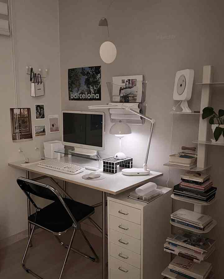 White tone home office space featuring a tidy desk, dresser, and lamp with a simple modern interior