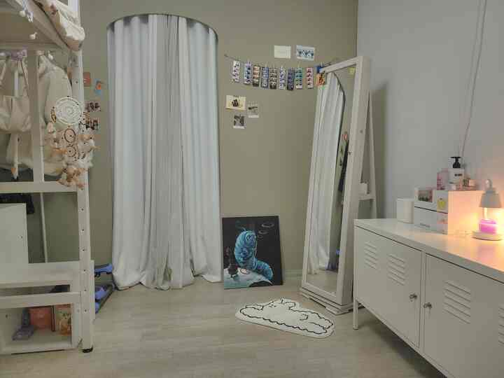 白とナチュラルカラーの玄関空間、シンプルなキャビネットと全身鏡が配置された雰囲気のあるインテリア