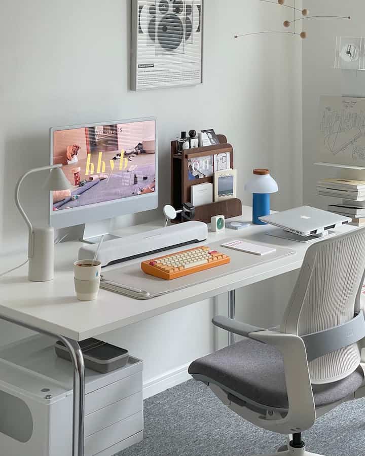 White and gray toned home office featuring iMac and office chair with a modern and tidy desk setup
